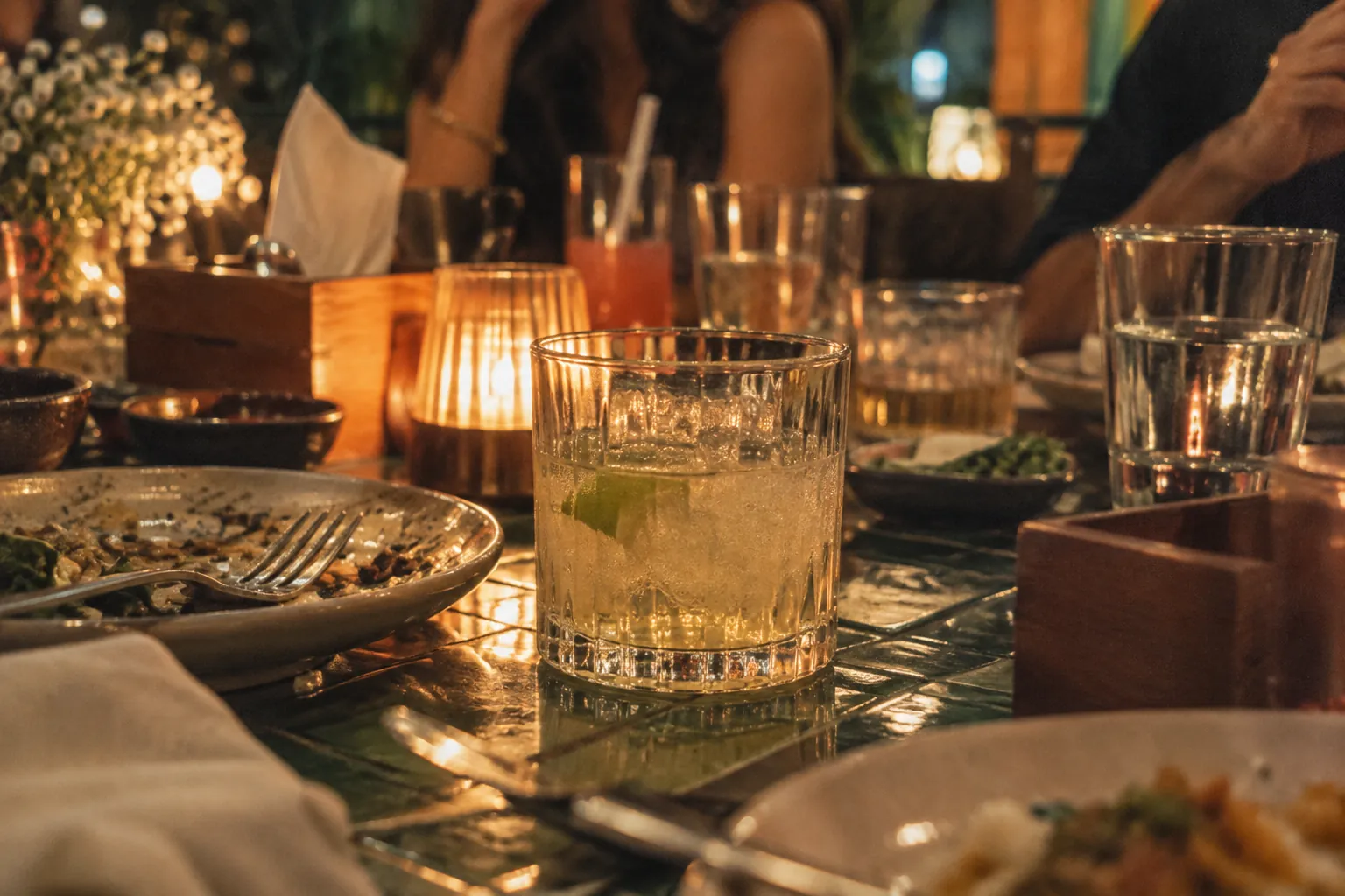 Candles, glasses and shared plates along the table