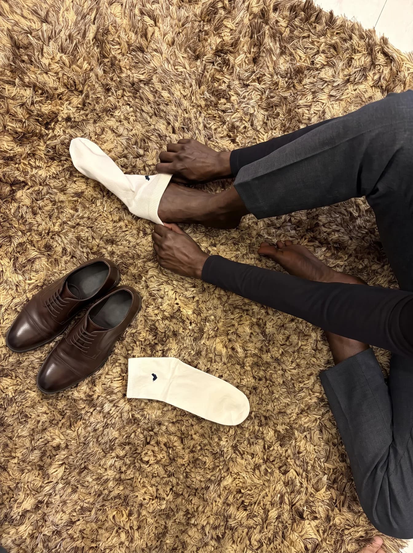 Pulling on Basalt Oat beside a pair of brown shoes